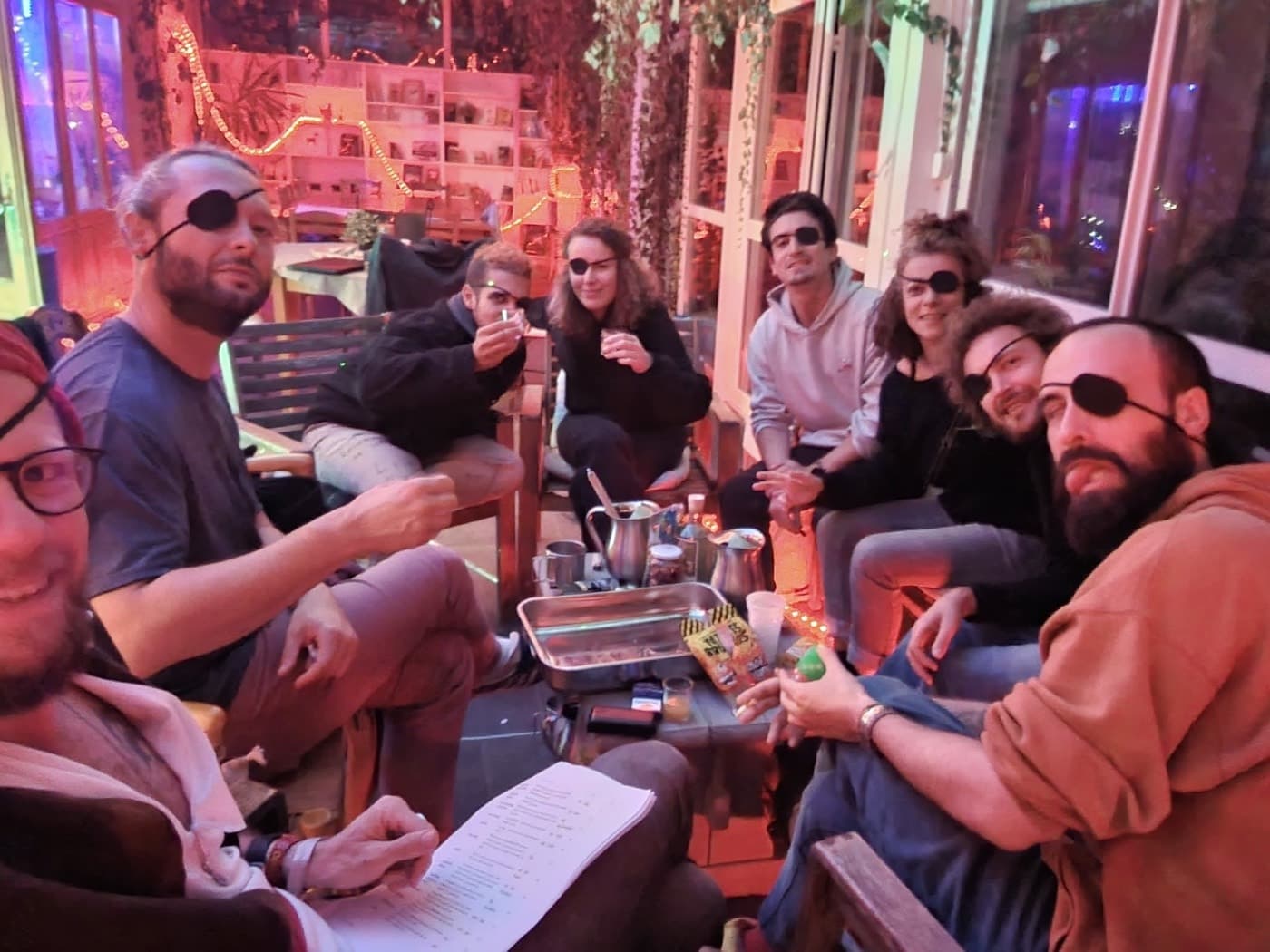 Un groupe d'amis en coliving, détendus et souriants en soirée, personne sur son téléphone