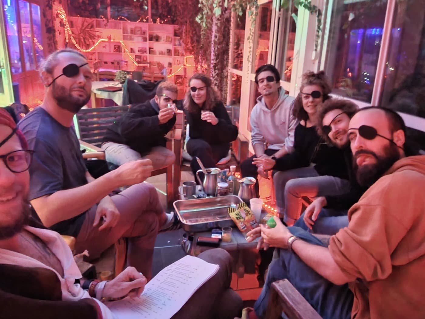 Un groupe d'amis en coliving, détendus et souriants en soirée, personne sur son téléphone